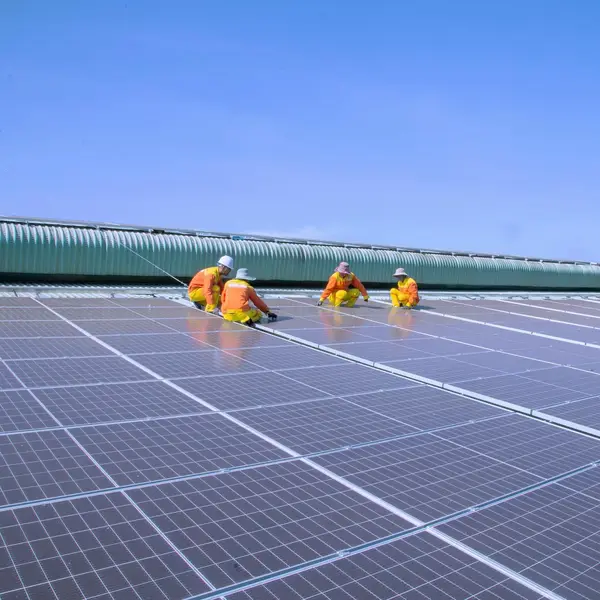 Solar workers installing solar panels on roof